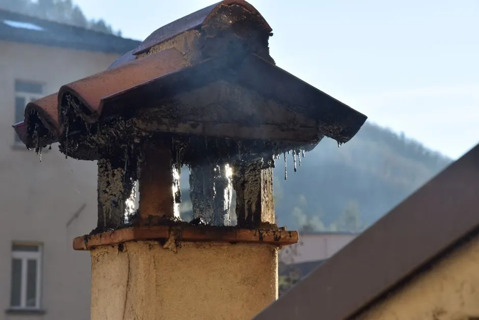 Close-up of a brick chimney stack releasing smoke, highlighting urban architecture.